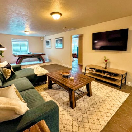 The basement game room comes equipped with a smart TV, a dry bar, and an air hockey table.