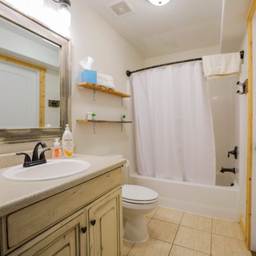 The downstairs bathroom features a tub/shower and is shared by Bedrooms #1 and #2. We provide shampoo, body wash, and conditioner!