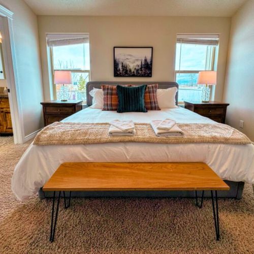 The primary bedroom features a king bed, a large en suite bathroom, and a walk-in closet.