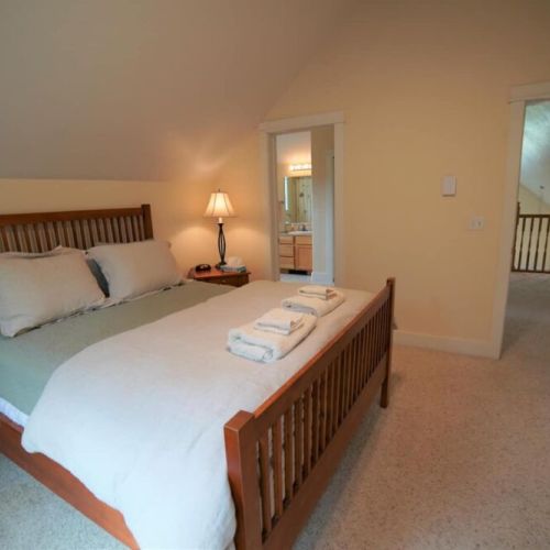 Upper bedroom has a queen bed and direct access to upper full bath.