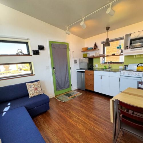 Living small does not mean going without — the comfortable living area, fully-equipped kitchen, and smart TV offer creature comforts not found in many other tiny homes.