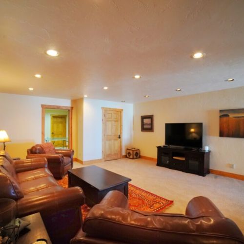 In the basement, there is a large sitting room with luxurious leather furniture and a TV with streaming capabilities.