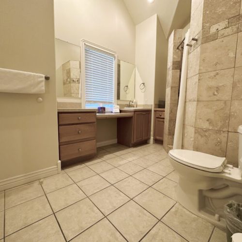 The upstairs bathroom has a large vanity, a walk-in shower, and plenty of storage place.