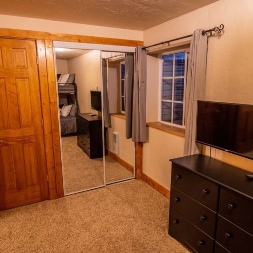 Down in the basement, bedroom #3 enjoys a twin-over-full bunk bed and an attached half-bath, as well as a TV — perfect for kids!