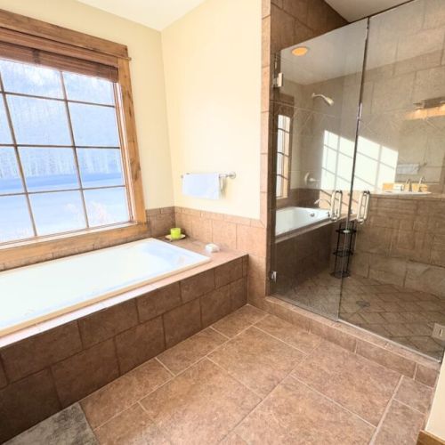 Bedroom #4 has its own bathroom on the lower level, complete with a double vanity, a huge tub, and a walk-in shower.