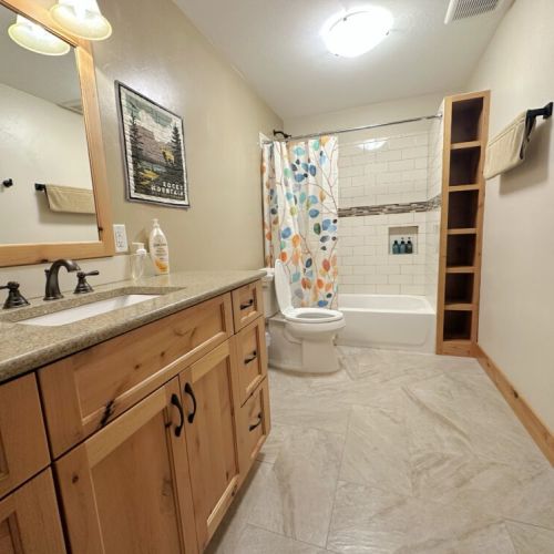 The downstairs bedroom and living area share this full bathroom, which has lots of storage space, a sizable vanity, and a tub/shower combo.