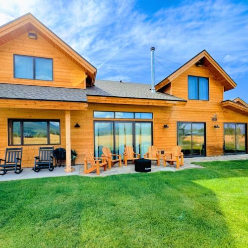 The backyard features a dining area, a firepit, and plenty of seating to enjoy the beautiful view.