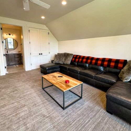 The entertainment room is located upstairs — featuring a large sectional, big wall-mounted TV, and its own en suite bathroom, this is the perfect hangout space.
