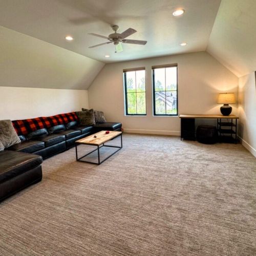 The entertainment room is located upstairs — featuring a large sectional, big wall-mounted TV, and its own en suite bathroom, this is the perfect hangout space.