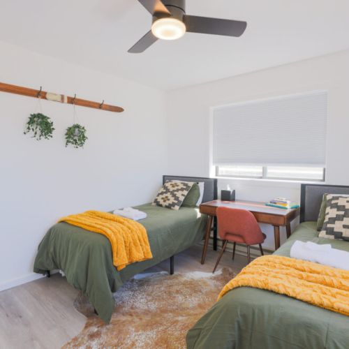 Bedroom #3 has two twin beds, a closet, a desk, and a view of the Tetons.