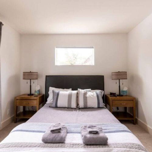 The master bedroom comes with a queen bed, a full en suite bath, and a lovely desk for reading or work. There is also a wall-mounted smart TV!