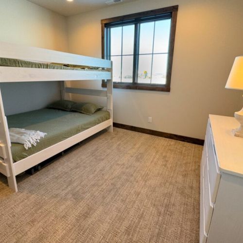 The second bedroom features a queen-over-queen bunk bed and plenty of storage space.