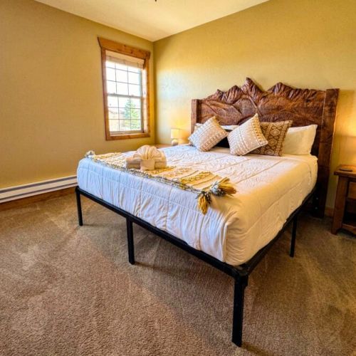 The primary bedroom enjoys a king bed with a custom Teton headboard. It also has an en suite bath and a desk for those who need to work-from-home.