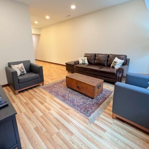 The basement living area features an array of comfortable seating as well as a smart TV.