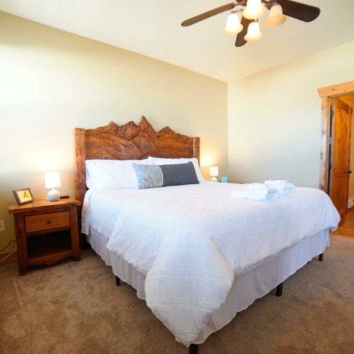 The master bedroom enjoys a king bed with a custom Teton headboard. It also has an en suite bath and its own TV.