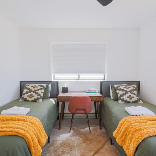 Bedroom #3 has two twin beds, a closet, a desk, and a view of the Tetons.