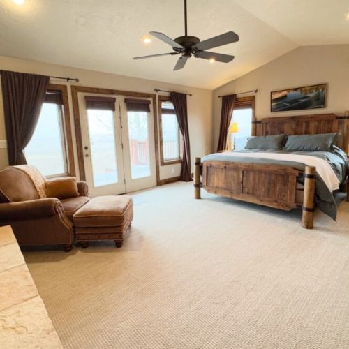 The primary bedroom features a king bed, a gas fireplace, a smart TV with a soundbar, a large en suite bathroom, and access to a private hot tub.