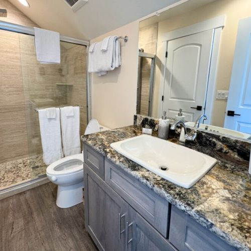 The Jack-and-Jill bathroom, which serves the entire unit, enjoys a spacious vanity and a lovely walk-in shower.