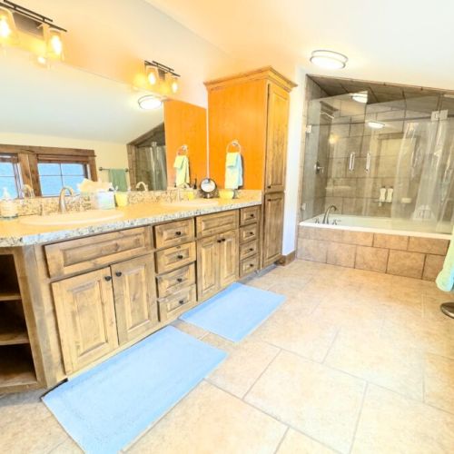The master en suite enjoys a spacious double vanity, a private water closet, and a large shower/tub.