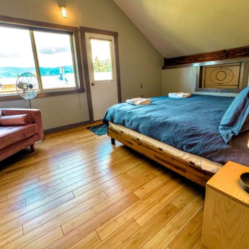 The upstairs bedroom has a king bed, closet space, and a comfy seat for lounging. This bedroom communicates through a small window to the living space on the first floor for heat conduction purposes.