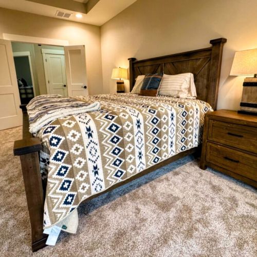 The primary bedroom features a king bed, a large en suite bathroom, a walk-in closet, and direct access to the back deck.