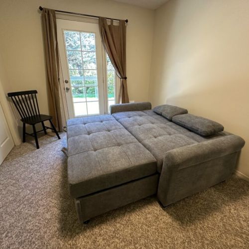 Bedroom #4 (Main Level) has a comfortable sofa that can be folded out into a queen-sized bed. It also enjoys direct access to the backyard, including the hot tub and propane BBQ.
