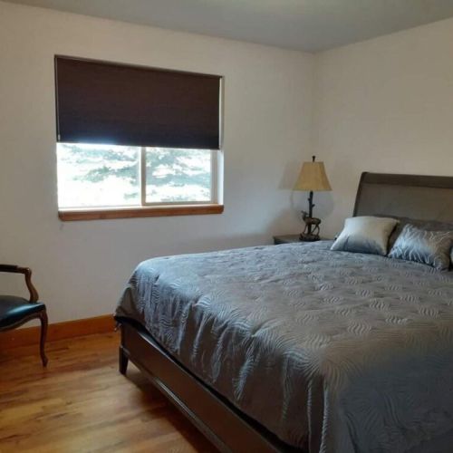 Bedroom #2 has a king bed, a reading chair, and an ample storage space.