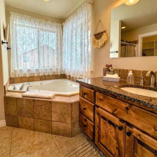 The primary en suite enjoys a large vanity, a luxurious jetted tub, and access to the walk-in closet.