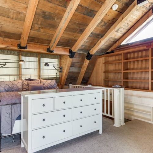 The master bedroom, located upstairs, has a king bed, en suite bathroom, a sauna, a dedicated workspace, and a private deck.