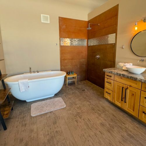 The en suite bath has a tub, a shower, a vanity, and a large mirror so you can get ready or wind down efficiently! There is also a private water closet.
