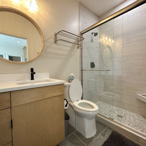 The unit's full bathroom enjoys a spacious vanity and a large walk-in shower.