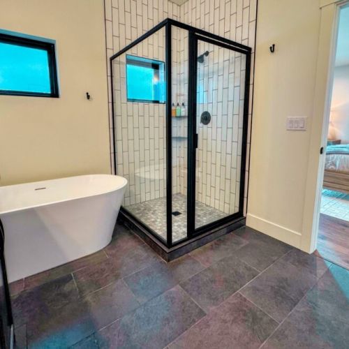 The primary en suite enjoys a large walk-in shower, a soaking tub, and a spacious double vanity.