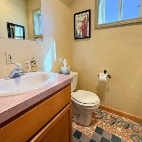 The upstairs half-bath is steps away from the king bed.