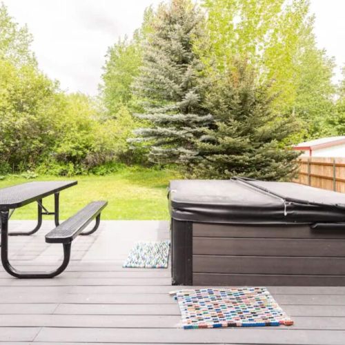 The hot tub is conveniently located steps outside the living room sliding doors.