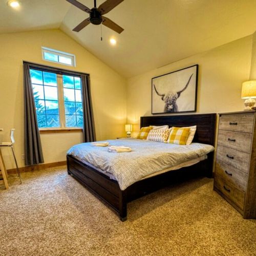 The master bedroom features a king bed, a dedicated work station with a computer monitor, and an en suite bath.