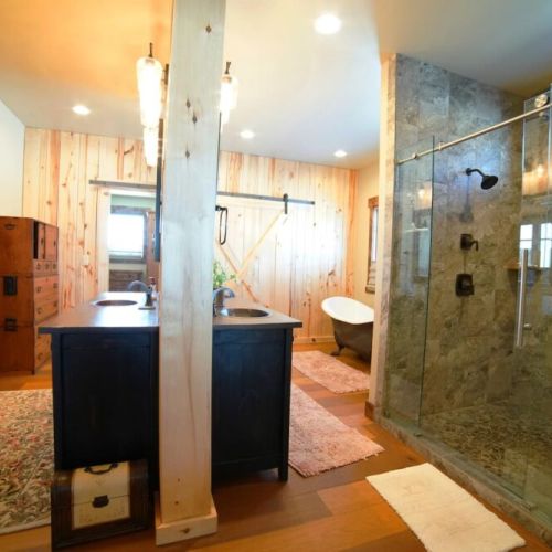 The master bath has a walk-in shower with his-and-hers shower heads. There is also a beautiful tub, three sinks, and plenty of space to store toiletries or other items.