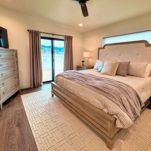 The primary bedroom features a king bed, views of the Tetons, a smart TV, and an expansive en suite bathroom.