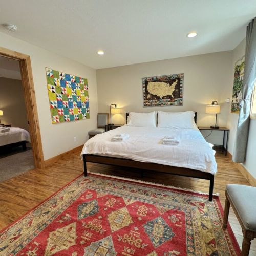 Two beds are in the shared living space — one queen and one king.