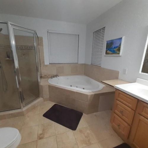 The master en suite bath has a double vanity, a spacious tub, and a walk-in shower.
