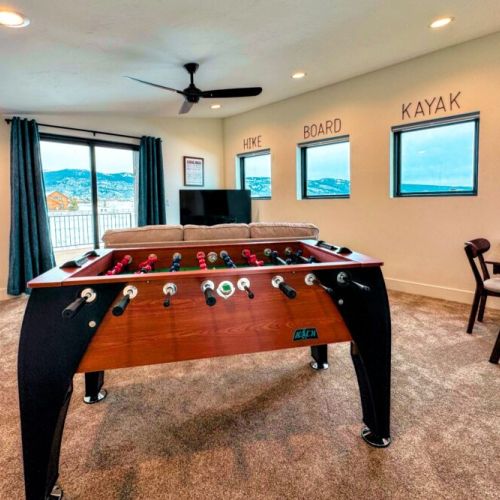 The upstairs living area has its own TV, a dedicated workspace, a foosball table, and a balcony with spectacular views of the mountains.
