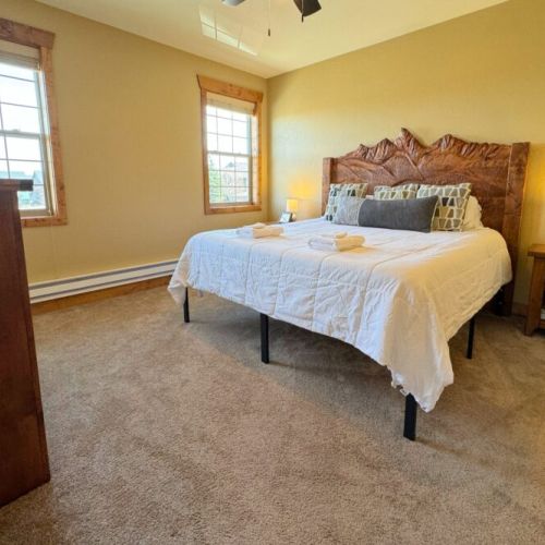 The primary bedroom enjoys a king bed with a custom Teton headboard. It also has an en suite bath and its own TV.