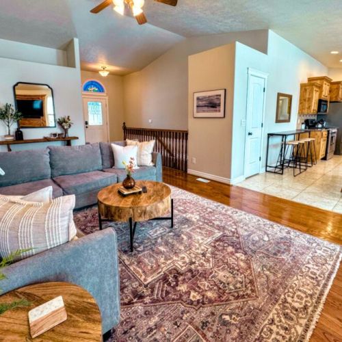 The spacious open-concept living area with cozy seating, a gas fireplace, and seamless flow leads straight to the dining room and kitchen.