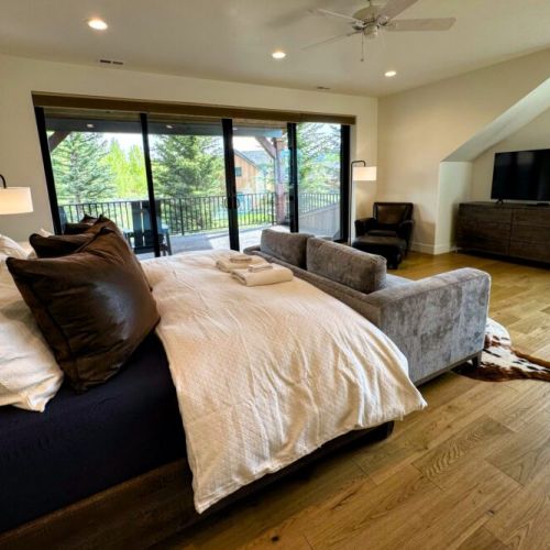Bedroom #4 (upstairs) is functionally another master! It comes with a king bed, a love seat, a TV, a large en suite, as well as a fantastic balcony overlooking the backyard.