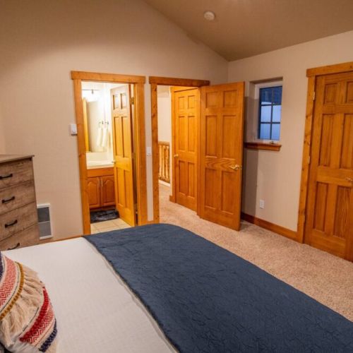 The master bedroom features a king bed, a dedicated work station with a computer monitor, and an en suite bath.
