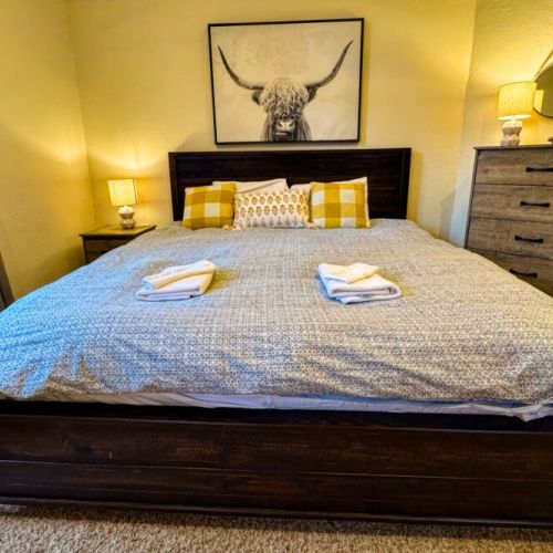 The master bedroom features a king bed, a dedicated work station with a computer monitor, and an en suite bath.