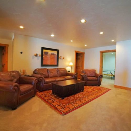 In the basement, there is a large sitting room with luxurious leather furniture and a TV with streaming capabilities.