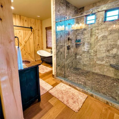 The master bath has a walk-in shower with his-and-hers shower heads. There is also a beautiful tub, three sinks, and plenty of space to store toiletries or other items.