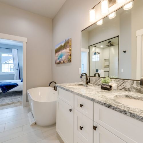 The primary en suite enjoys a spacious double vanity, a luxurious step-in shower, and a soaking tub.