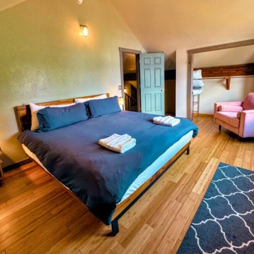 The upstairs bedroom has a king bed, closet space, and a comfy seat for lounging. This bedroom communicates through a small window to the living space on the first floor for heat conduction purposes.