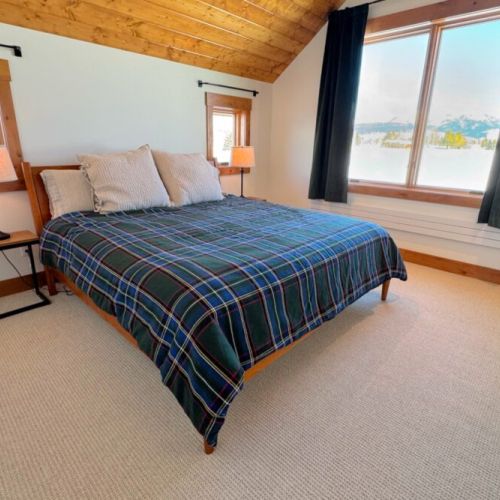 The primary bedroom (located upstairs) features a king bed, a walk-in closet, an en suite bathroom, and a direct view of the Tetons.